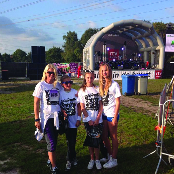 Deelnemers aan de Collor Run met de opblaasbare podiumwagen op de achtergrond